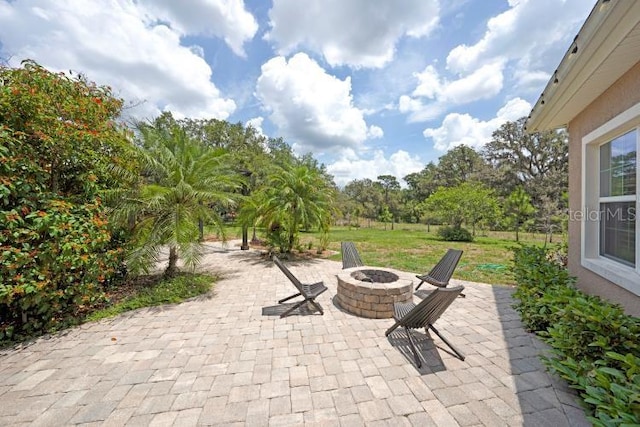 14223 Lambert Bridge Ln, Lithia, FL 33547 - view of patio / terrace with an outdoor fire pit
