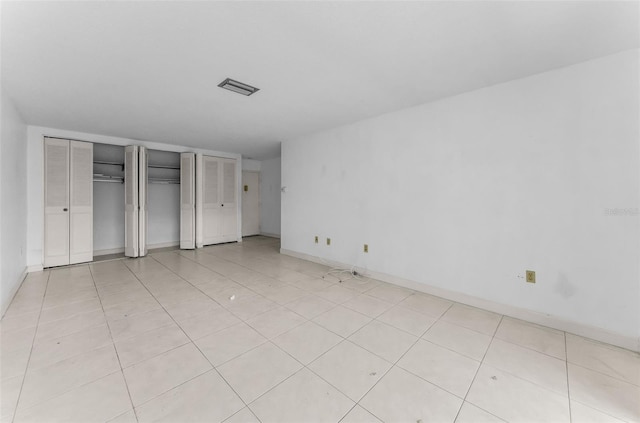 2700 Bayshore Blvd Unit 2110, Dunedin, FL 34698 - unfurnished bedroom featuring multiple closets, light tile patterned floors, and baseboards