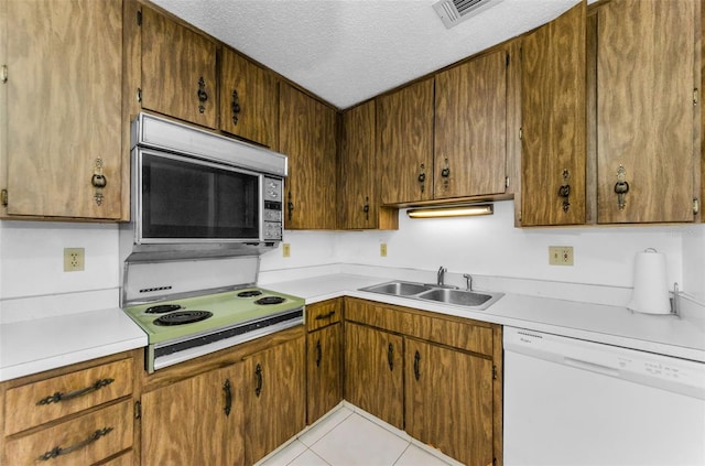 2700 Bayshore Blvd Unit 2110, Dunedin, FL 34698 - kitchen with stainless steel microwave, white dishwasher, a sink, a textured ceiling, and light countertops