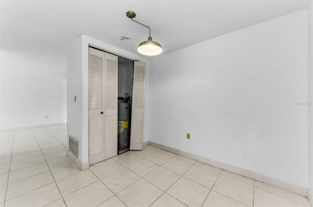 2700 Bayshore Blvd Unit 2110, Dunedin, FL 34698 - unfurnished room featuring light tile patterned floors, baseboards, and water heater