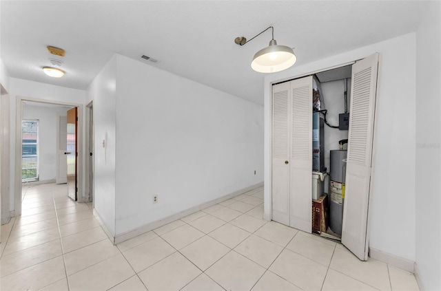 2700 Bayshore Blvd Unit 2110, Dunedin, FL 34698 - spare room featuring water heater, light tile patterned floors, and baseboards