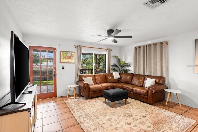 1045 28th Ave S, Saint Petersburg, FL 33705 - living area with light tile patterned flooring, healthy amount of natural light, ceiling fan, baseboards, and a textured ceiling