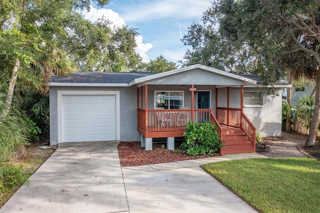 1045 28th Ave S, Saint Petersburg, FL 33705 - view of front of home featuring a porch, a garage, stucco siding, and driveway