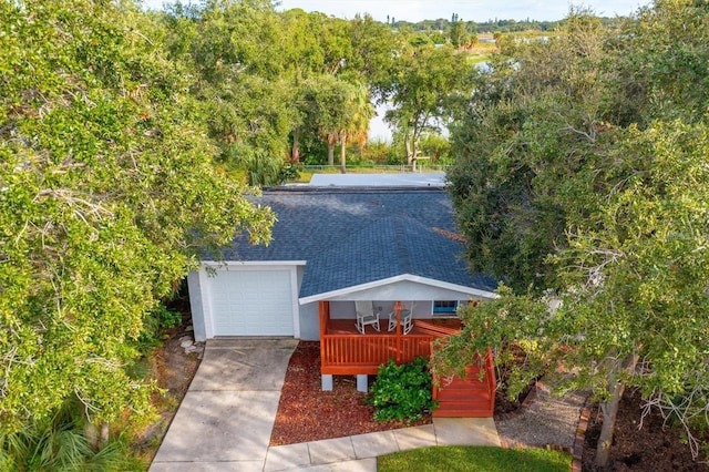 1045 28th Ave S, Saint Petersburg, FL 33705 - view of front facade with a shingled roof, a garage, and driveway