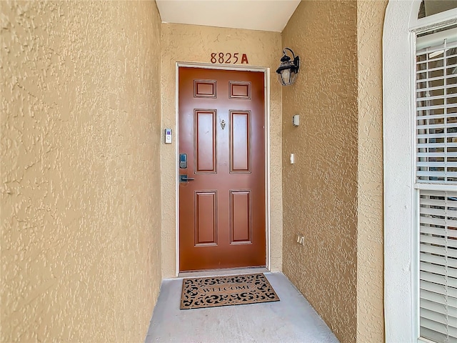 doorway to property featuring stucco siding