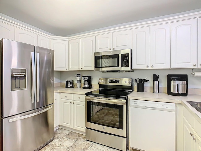 kitchen featuring appliances with stainless steel finishes, white cabinets, and light countertops