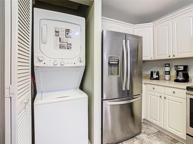 laundry room with stacked washer / drying machine and light marble finish flooring