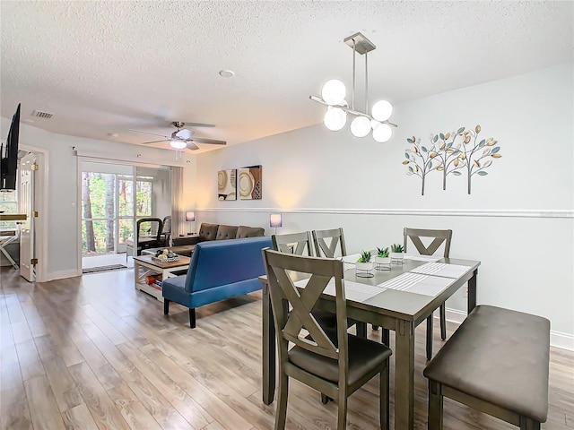 dining space with a textured ceiling, light wood-type flooring, ceiling fan, and baseboards
