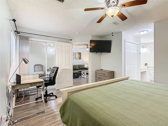 bedroom featuring a textured ceiling, wood finished floors, a ceiling fan, and a desk