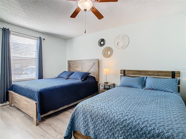 bedroom featuring a textured ceiling, wood finished floors, and a ceiling fan