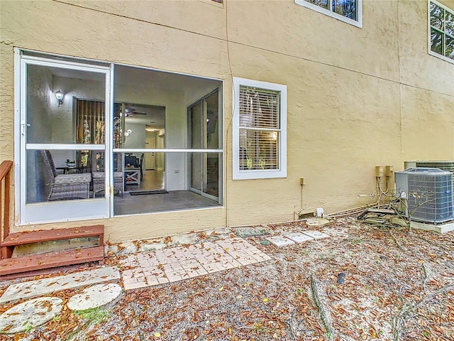 property entrance featuring central AC unit and stucco siding