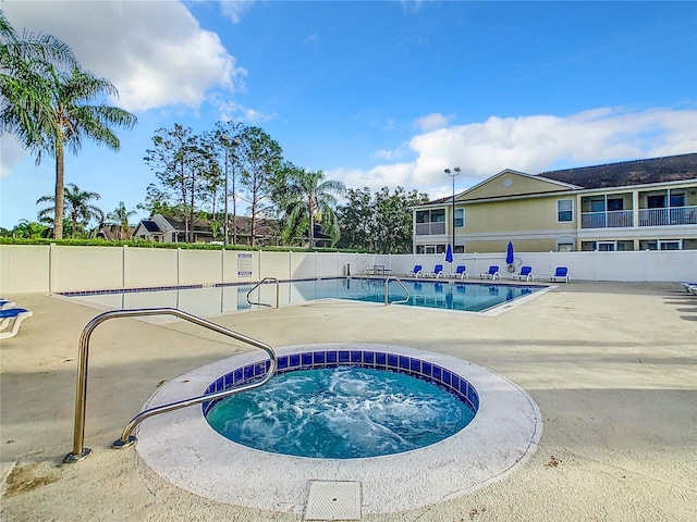 community pool with a community hot tub and a patio