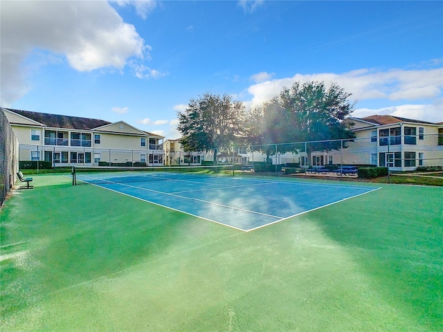 view of tennis court with a residential view