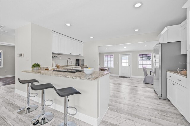 812 60th St S, Gulfport, FL 33707 - kitchen featuring light wood-type flooring, white cabinets, recessed lighting, and baseboards