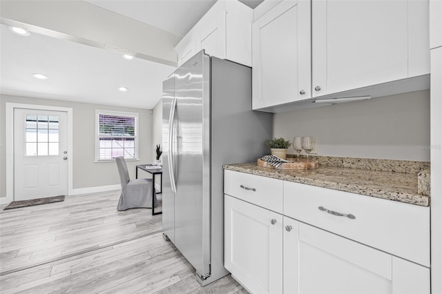812 60th St S, Gulfport, FL 33707 - kitchen with freestanding refrigerator, white cabinetry, light wood-type flooring, light stone countertops, and recessed lighting