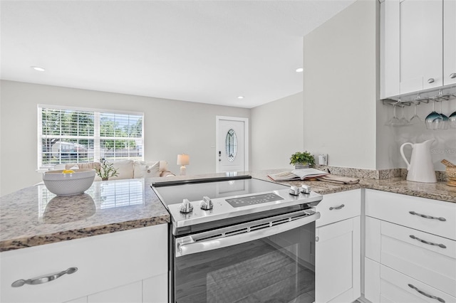 812 60th St S, Gulfport, FL 33707 - kitchen with stainless steel electric stove, light stone countertops, white cabinets, a peninsula, and recessed lighting