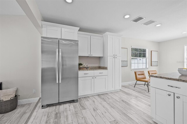 812 60th St S, Gulfport, FL 33707 - kitchen featuring freestanding refrigerator, white cabinets, stone counters, baseboards, and recessed lighting