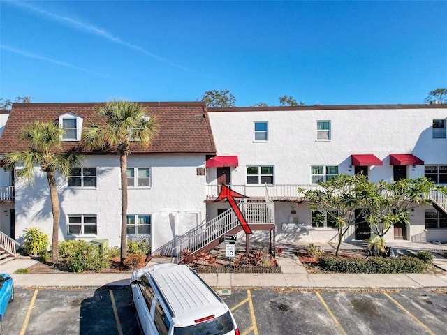 9201 Tudor Dr Unit C212, Tampa, FL 33615 - view of building exterior featuring uncovered parking and stairway