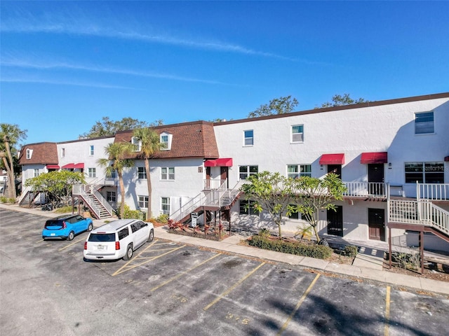 9201 Tudor Dr Unit C212, Tampa, FL 33615 - view of building exterior with stairway, uncovered parking, and a residential view