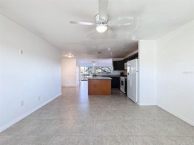 9201 Tudor Dr Unit C212, Tampa, FL 33615 - kitchen with a ceiling fan, open floor plan, a kitchen island, baseboards, and white refrigerator with ice dispenser