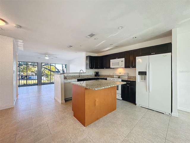 9201 Tudor Dr Unit C212, Tampa, FL 33615 - kitchen featuring white appliances, a sink, a center island, ceiling fan, and open floor plan