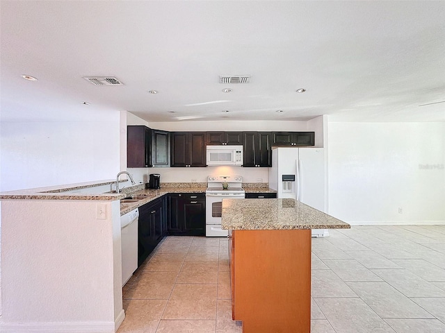 9201 Tudor Dr Unit C212, Tampa, FL 33615 - kitchen featuring white appliances, a sink, a center island, light stone counters, and recessed lighting