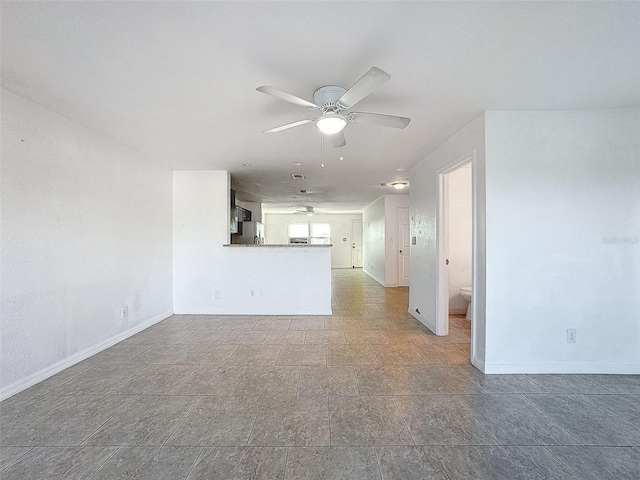 9201 Tudor Dr Unit C212, Tampa, FL 33615 - unfurnished living room with a ceiling fan, baseboards, and stone finish flooring