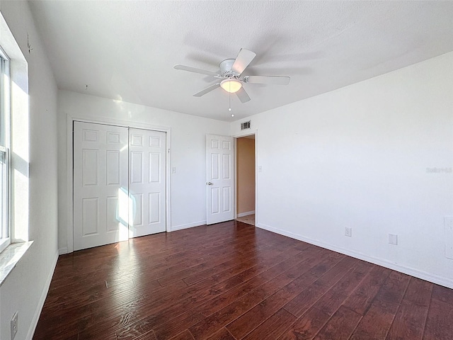 9201 Tudor Dr Unit C212, Tampa, FL 33615 - unfurnished bedroom featuring wood finished floors, multiple windows, a closet, and baseboards