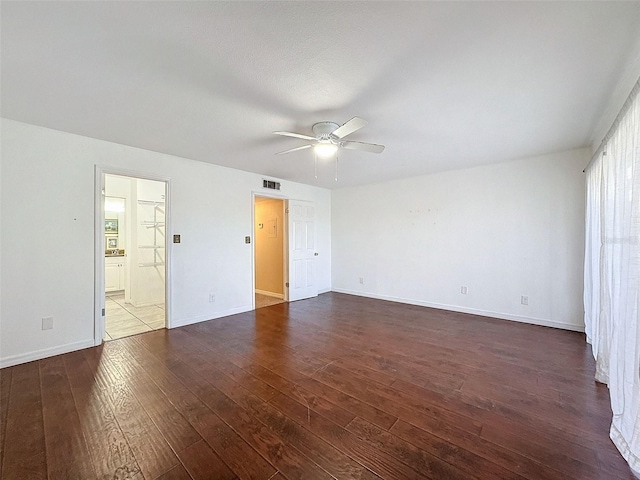 9201 Tudor Dr Unit C212, Tampa, FL 33615 - unfurnished bedroom featuring dark wood finished floors, baseboards, connected bathroom, and a ceiling fan