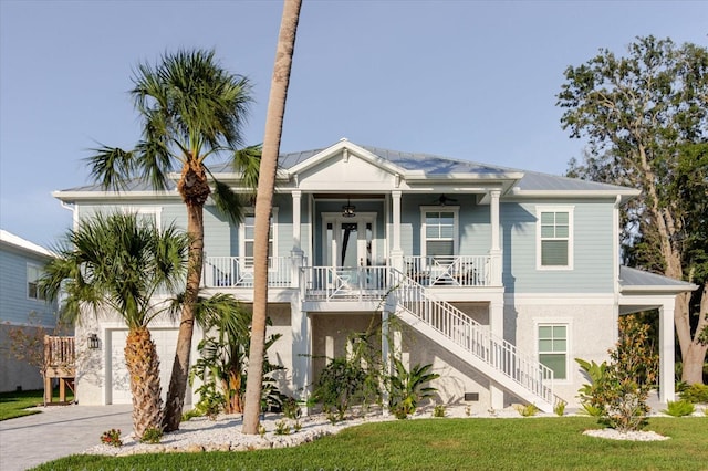 216 High St, Tarpon Springs, FL 34689 - view of front of home featuring covered porch, a ceiling fan, stairs, driveway, and a front lawn