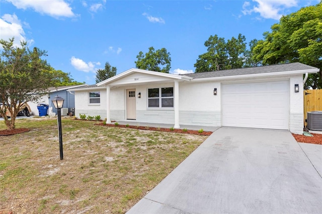 9241 Cochise Ln, Port Richey, FL 34668 - ranch-style house with an attached garage, central AC, driveway, a front lawn, and stucco siding