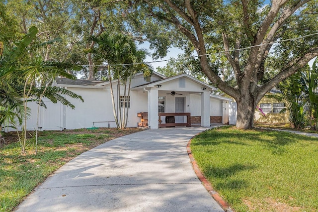 3310 W Ballast Point Blvd, Tampa, FL 33611 - view of front of home featuring ceiling fan, a front lawn, stucco siding, concrete driveway, and a porch