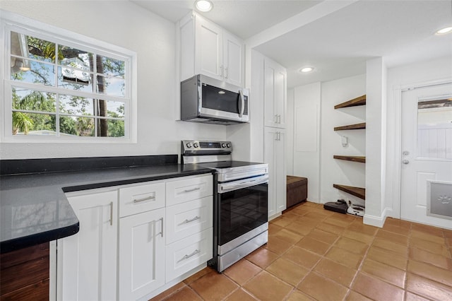 3310 W Ballast Point Blvd, Tampa, FL 33611 - kitchen featuring appliances with stainless steel finishes, dark countertops, white cabinetry, open shelves, and recessed lighting