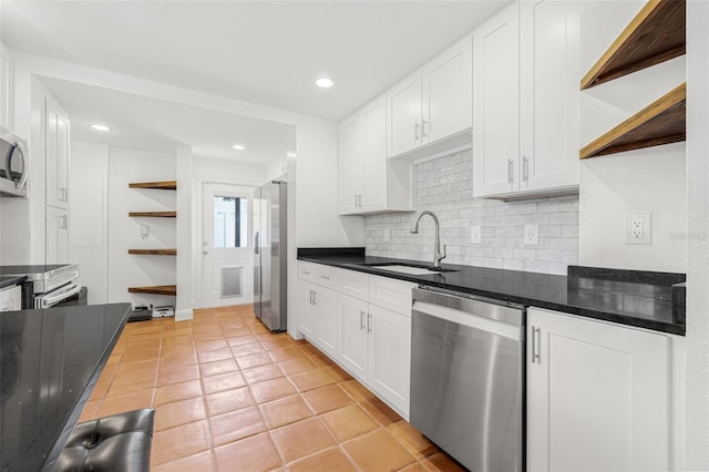 3310 W Ballast Point Blvd, Tampa, FL 33611 - kitchen with stainless steel appliances, open shelves, a sink, backsplash, and white cabinetry