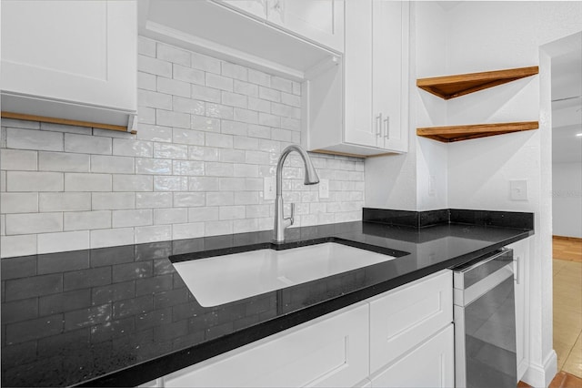 3310 W Ballast Point Blvd, Tampa, FL 33611 - kitchen featuring a sink, open shelves, stainless steel dishwasher, white cabinets, and tasteful backsplash