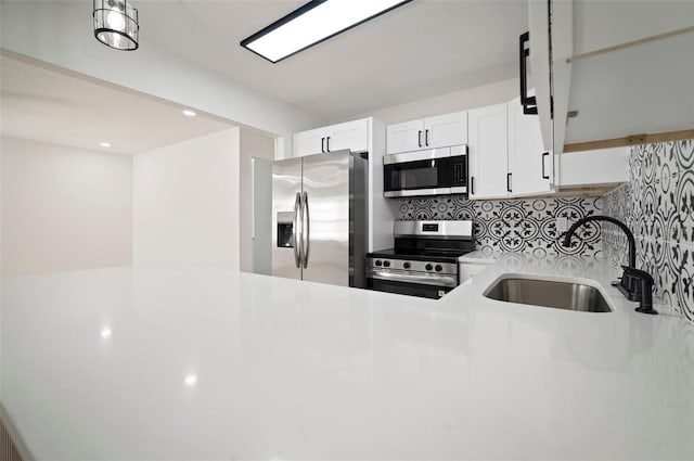 5405 S Sellas St, Tampa, FL 33611 - kitchen featuring appliances with stainless steel finishes, a sink, tasteful backsplash, light countertops, and white cabinets