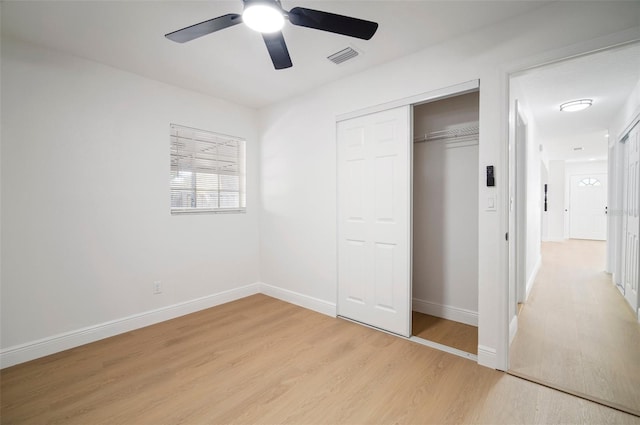 5405 S Sellas St, Tampa, FL 33611 - unfurnished bedroom with light wood-style flooring, a closet, baseboards, and a ceiling fan