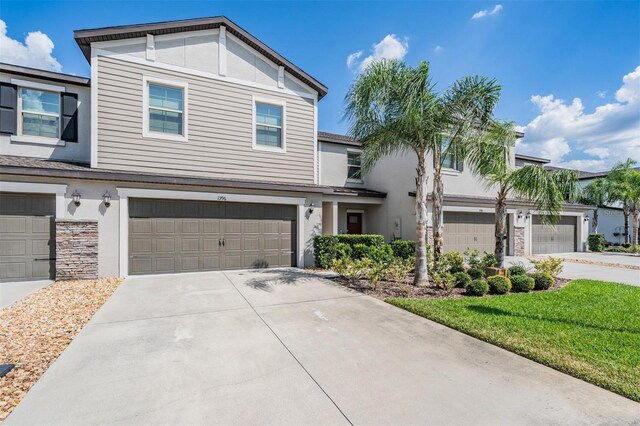 1396 White Fox Run, Lutz, FL 33549 - view of front facade with concrete driveway, stucco siding, a garage, and stone siding