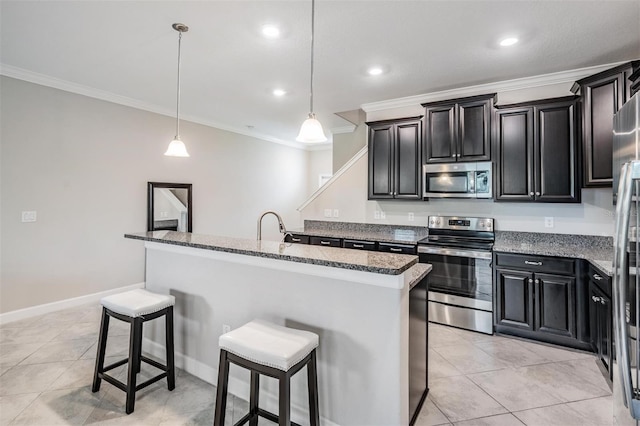 1396 White Fox Run, Lutz, FL 33549 - kitchen with appliances with stainless steel finishes, a kitchen breakfast bar, ornamental molding, dark cabinets, and a kitchen island with sink