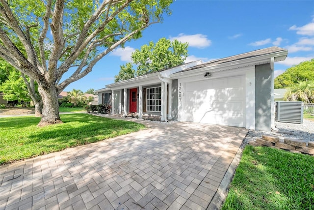 12401 Yorktown Ln, Bayonet Point, FL 34667 - ranch-style home with a garage, a front yard, decorative driveway, and stucco siding