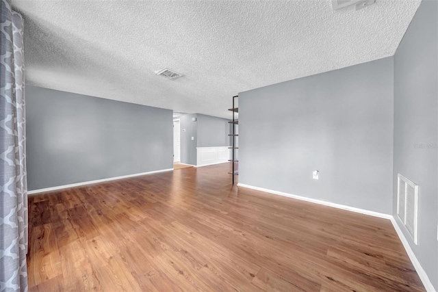 12401 Yorktown Ln, Bayonet Point, FL 34667 - spare room with a textured ceiling, wood finished floors, and baseboards