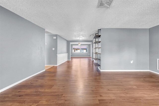 12401 Yorktown Ln, Bayonet Point, FL 34667 - unfurnished living room with wood finished floors, a textured ceiling, and baseboards