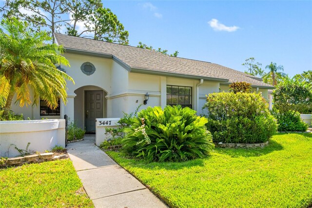 3447 Killdeer Pl, Palm Harbor, FL 34685 - view of front of home with stucco siding and a shingled roof