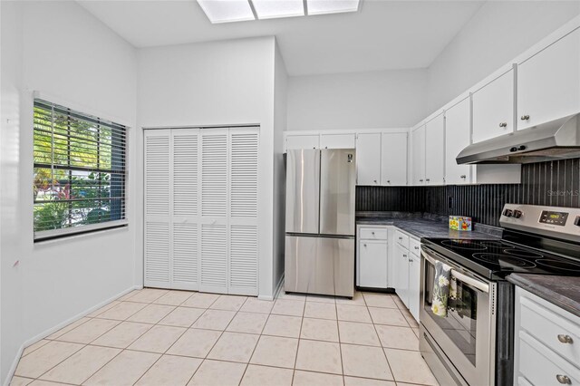 3447 Killdeer Pl, Palm Harbor, FL 34685 - kitchen featuring stainless steel appliances, under cabinet range hood, dark countertops, backsplash, and white cabinetry