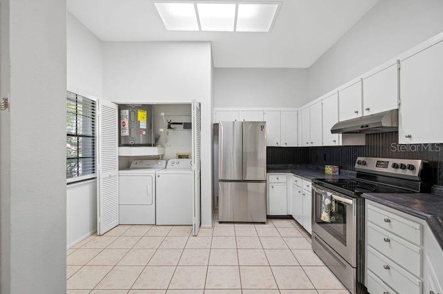 3447 Killdeer Pl, Palm Harbor, FL 34685 - kitchen with appliances with stainless steel finishes, under cabinet range hood, independent washer and dryer, dark countertops, and white cabinets