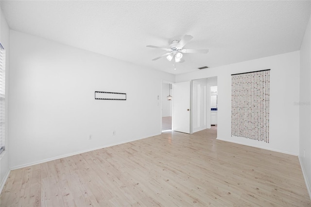 3447 Killdeer Pl, Palm Harbor, FL 34685 - empty room featuring light wood finished floors, a ceiling fan, baseboards, and a textured ceiling