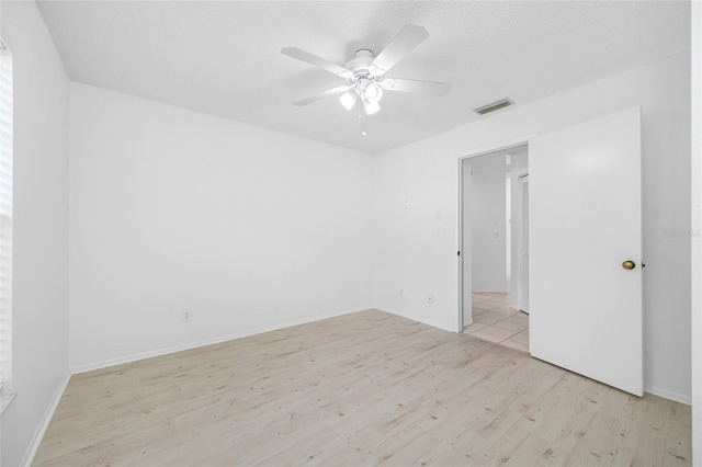 3447 Killdeer Pl, Palm Harbor, FL 34685 - spare room with light wood finished floors, ceiling fan, and a textured ceiling