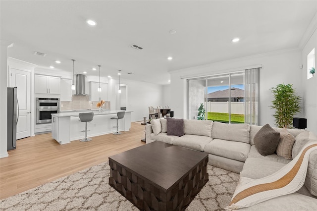 9271 Rally Spring Loop, Wesley Chapel, FL 33545 - living room featuring crown molding, light wood-type flooring, and recessed lighting