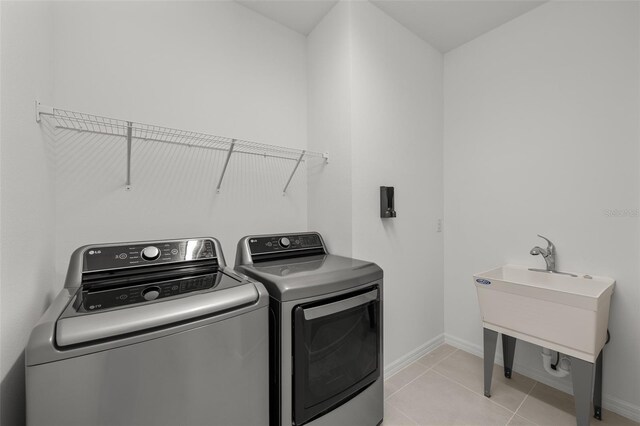 9271 Rally Spring Loop, Wesley Chapel, FL 33545 - laundry area featuring washer and dryer, light tile patterned floors, and baseboards