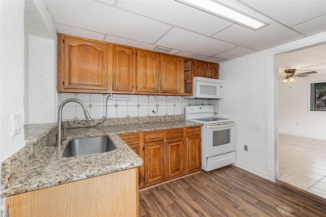 130 E Pendleton Ave, Eustis, FL 32726 - kitchen featuring white appliances, a sink, light stone countertops, tasteful backsplash, and brown cabinetry